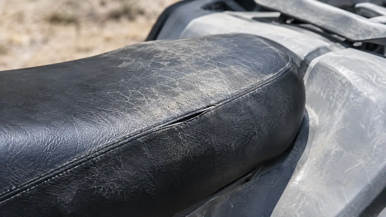 Close view of a sun faded and cracked quad seat beside sun bleached front plastics